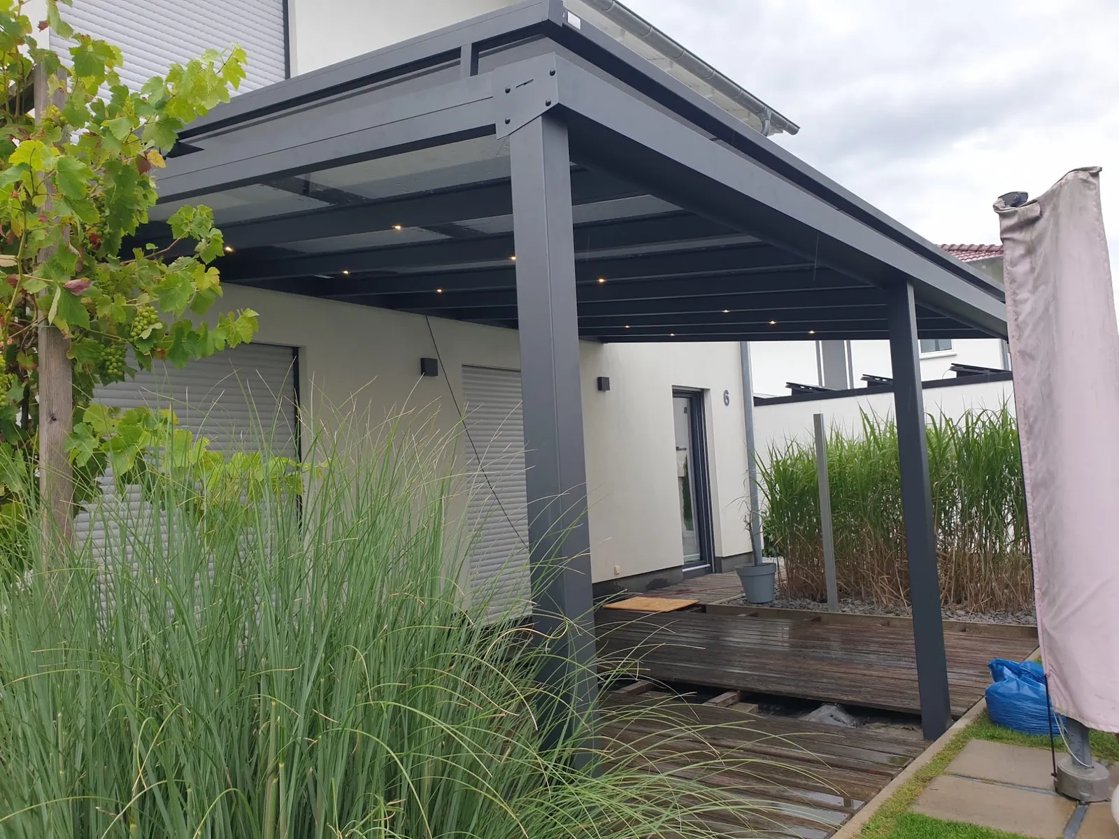 Terrassendach mit warmweißen LED-Spots über Holzdeck